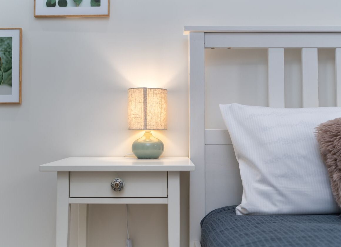 Cozy bedroom nightstand with warm lamp light, set up for a calming bedtime routine
