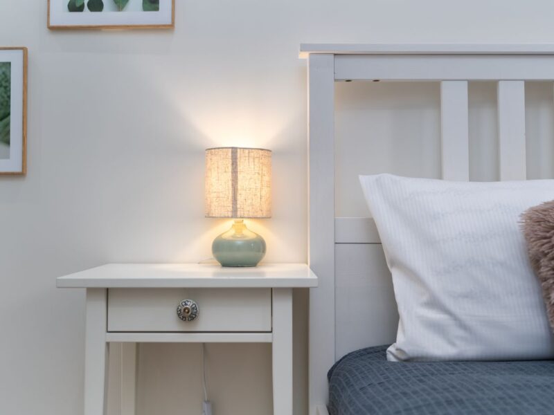 Cozy bedroom nightstand with warm lamp light, set up for a calming bedtime routine