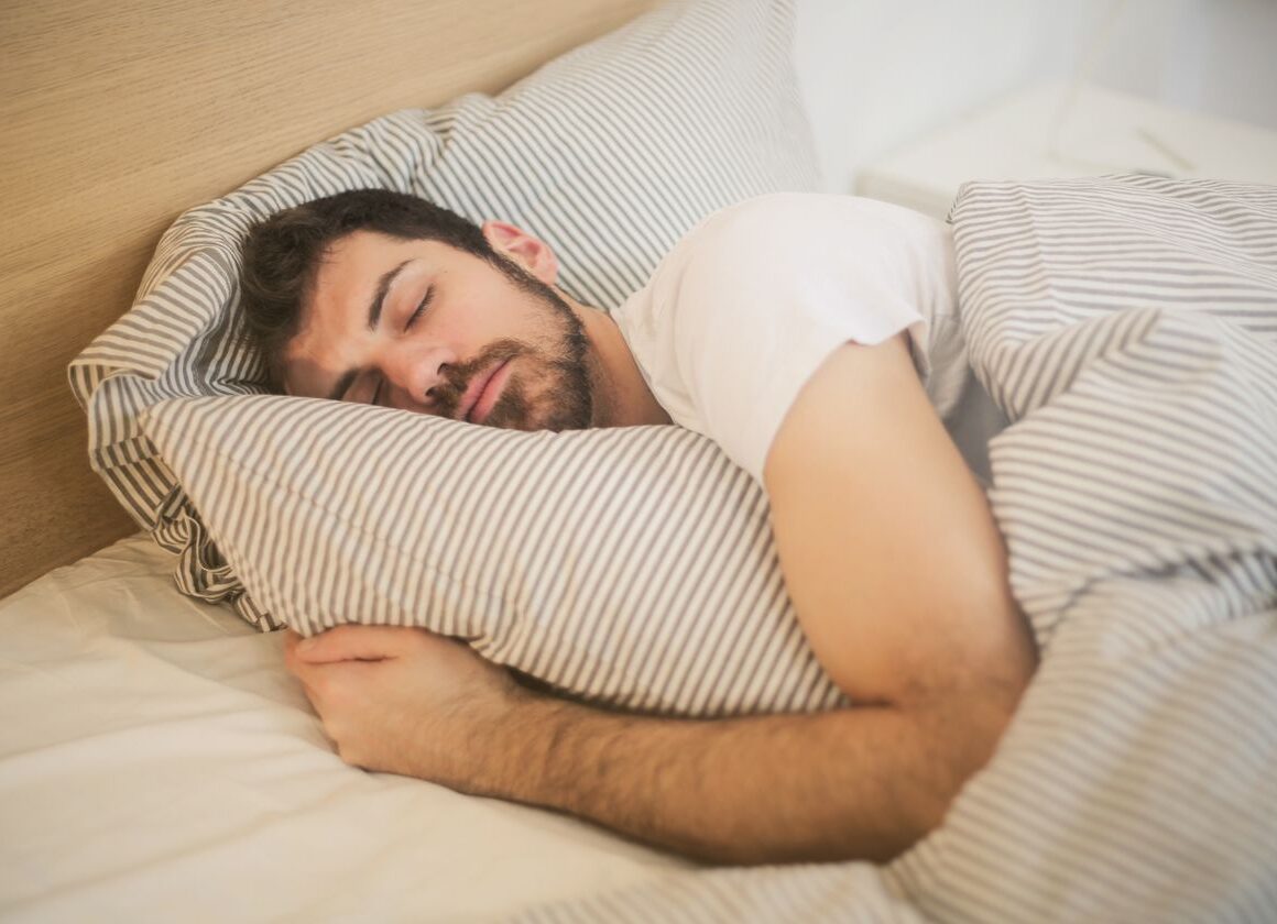 Person lying awake in bed at night unable to sleep, insomnia concept