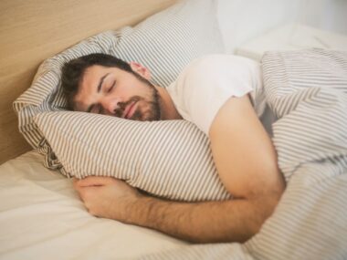 Person lying awake in bed at night unable to sleep, insomnia concept