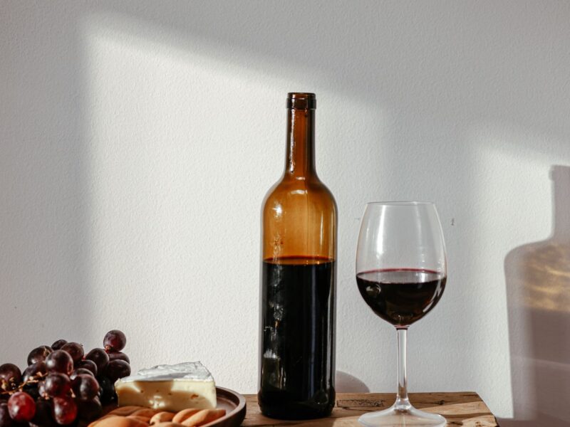 A glass of red wine on a wooden table in warm evening light