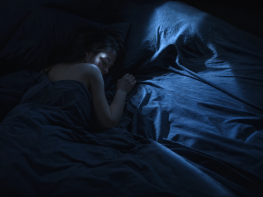 How much deep sleep do you need - person sleeping in dark moody bedroom